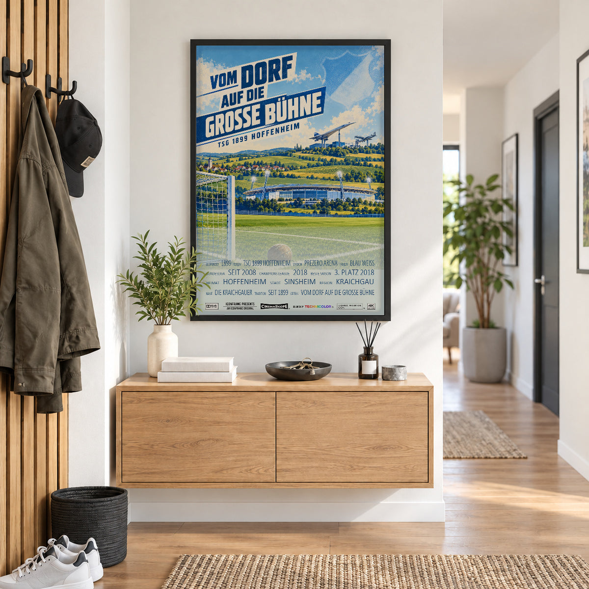TSG Hoffenheim Poster „Vom Dorf auf die große Bühne“ im schwarzen Rahmen über einer Holzkommode
