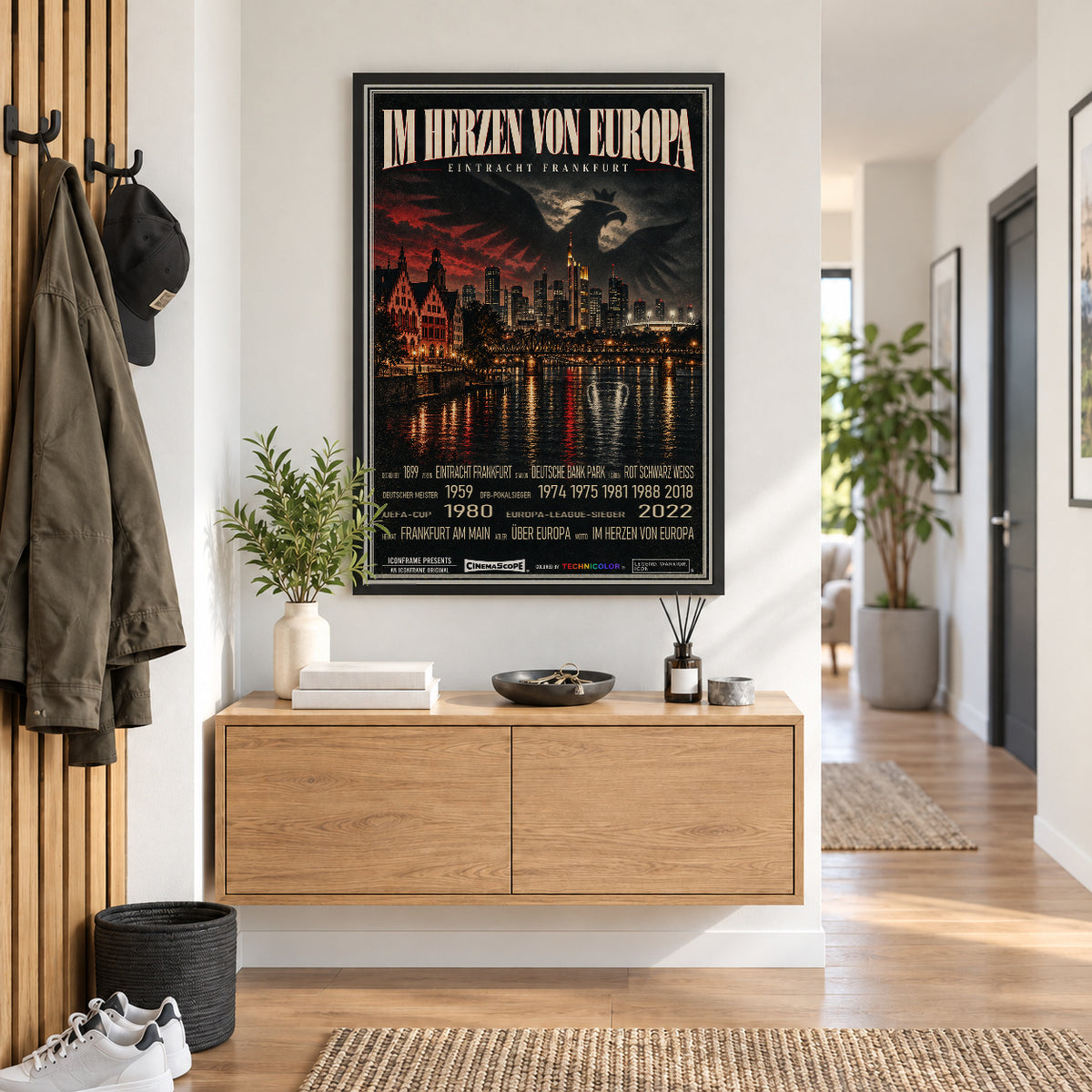 Eintracht Frankfurt Poster „Im Herzen von Europa“ im schwarzen Rahmen über einer Holzkommode