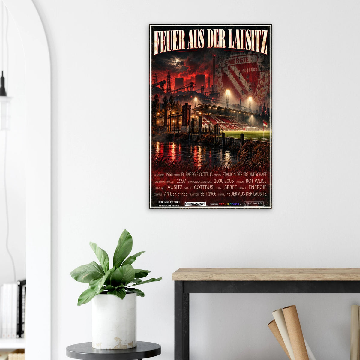 Energie Cottbus Poster „Feuer aus der Lausitz“ an einer hellen Wand neben einer Pflanze und einem Tisch