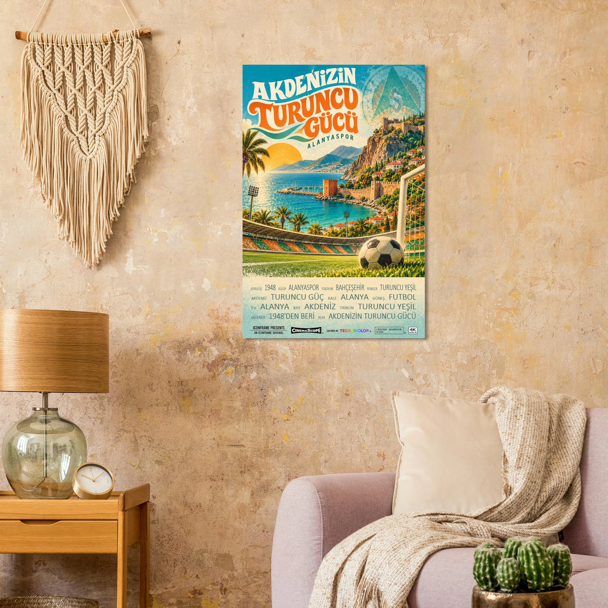 Alanyaspor Poster „Akdeniz’in Turuncu Gücü“ an einer beigen Wand neben einem Sessel und einer Tischlampe