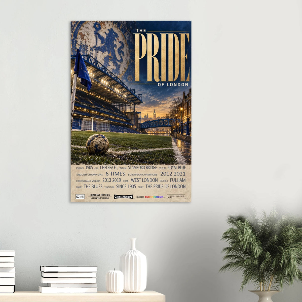 Chelsea Poster „The Pride of London“ an einer hellen Wand über Büchern und weißen Vasen