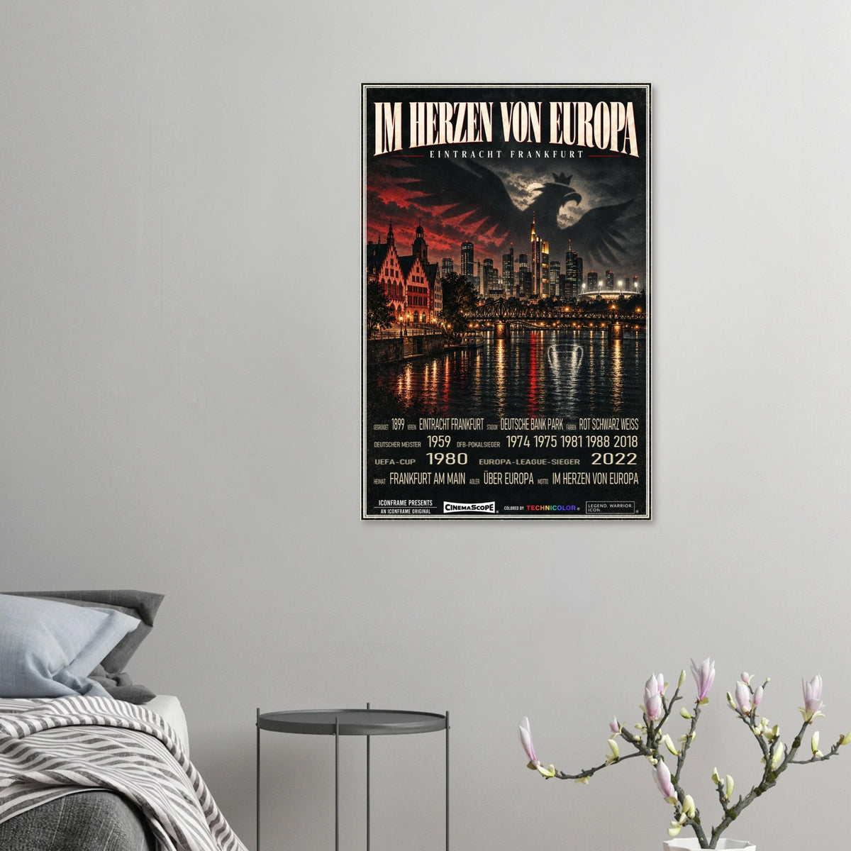 Eintracht Frankfurt Poster „Im Herzen von Europa“ an einer grauen Wand neben einem Bett