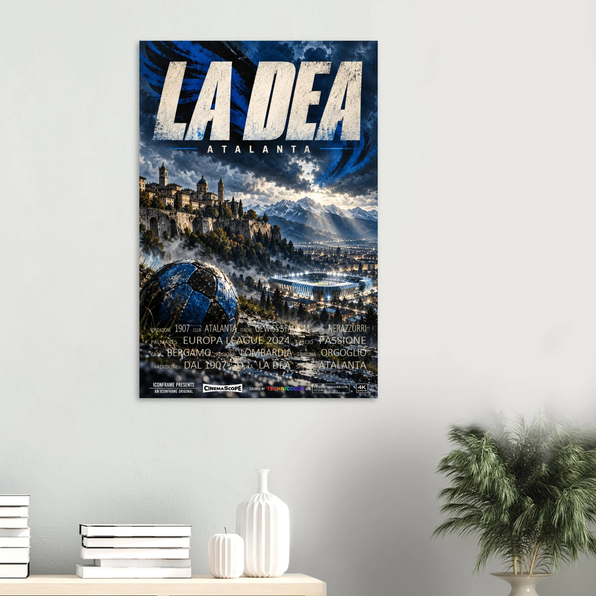 Atalanta Bergamo Poster „La Dea“ an einer hellen Wand über einer Ablage mit Büchern und Vasen