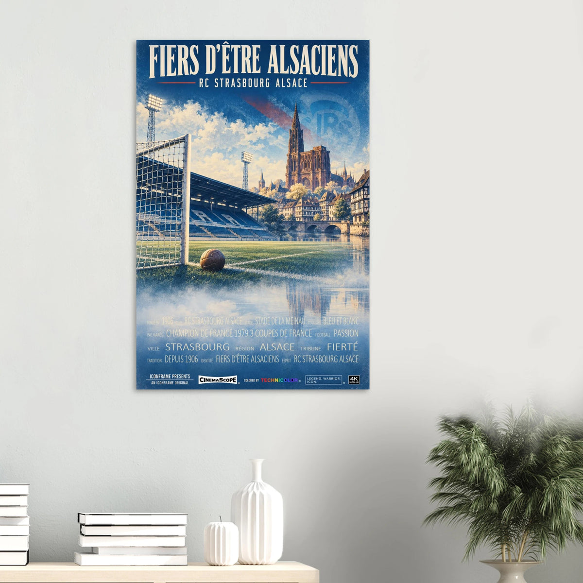 Racing Straßburg Poster „Fiers d’être Alsaciens“ an einer hellen Wand über einer Ablage mit Büchern und Vasen