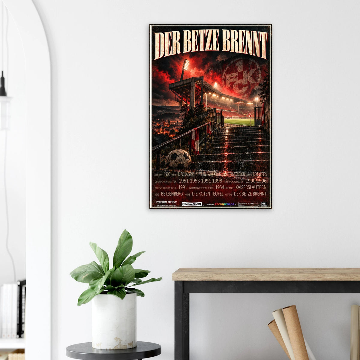 1. FC Kaiserslautern Poster „Der Betze brennt“ an einer hellen Wand neben einer Pflanze und einem Tisch
