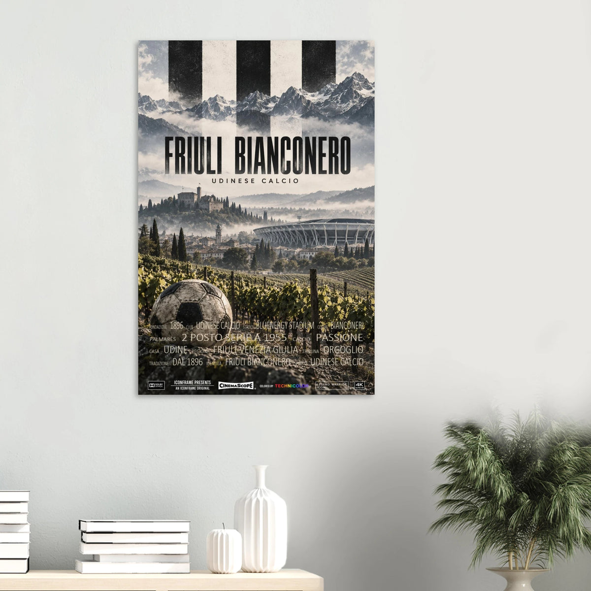 Udinese Calcio Poster „Friuli Bianconero“ an einer hellen Wand über einer Ablage mit Büchern und Vasen