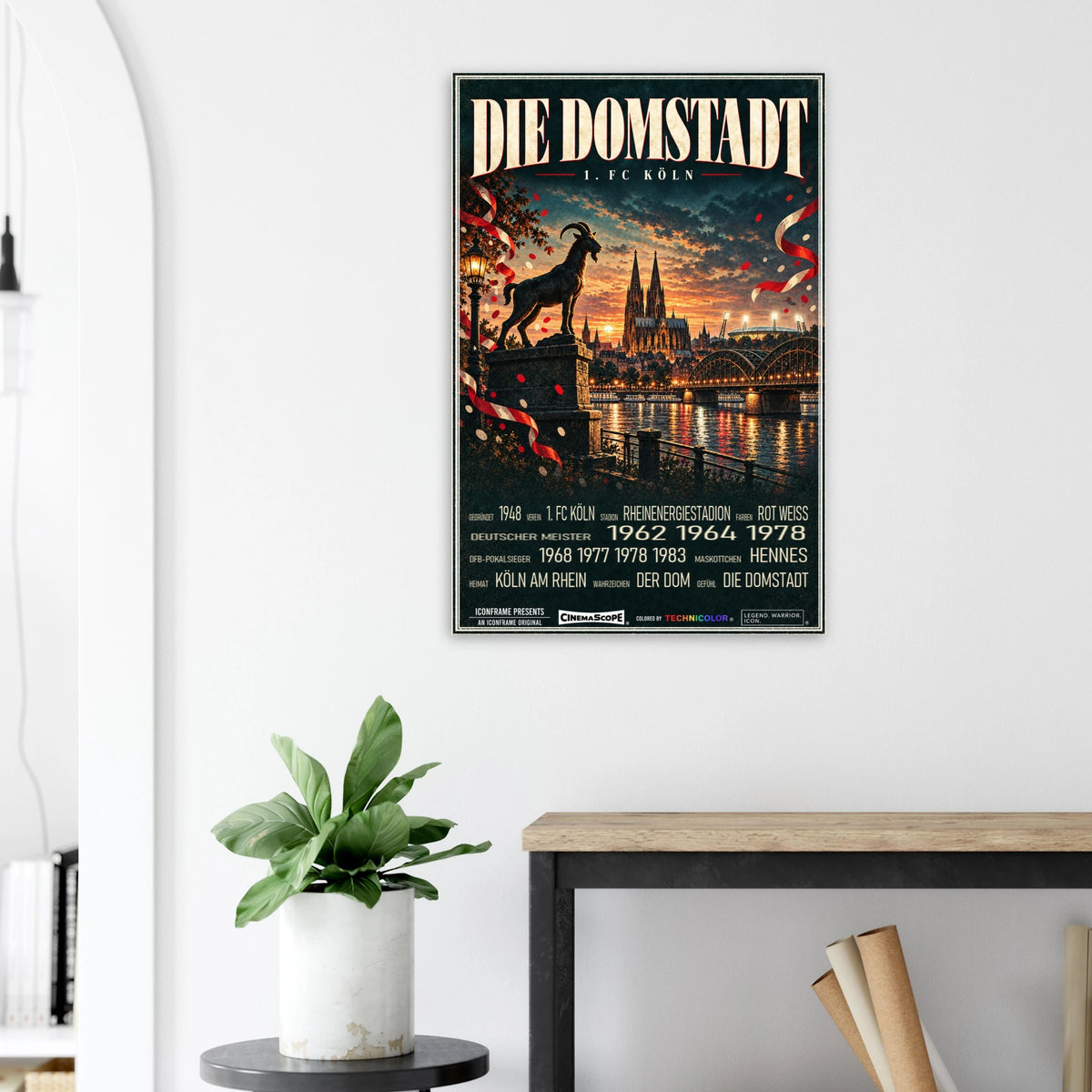 1. FC Köln Poster „Die Domstadt“ an einer hellen Wand neben einer Pflanze und einem Tisch
