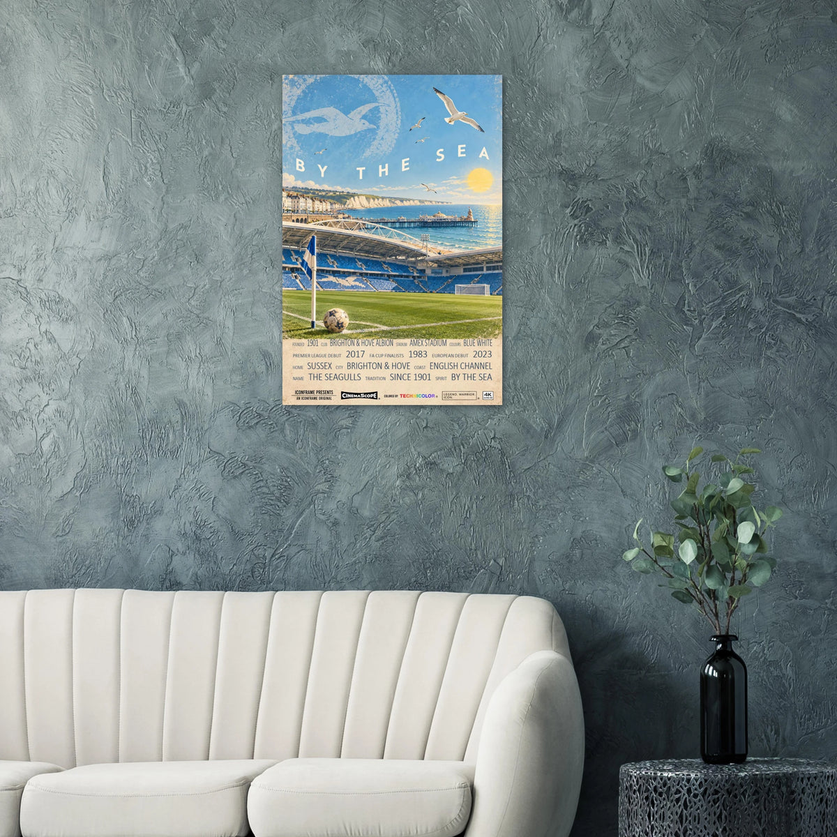 Brighton & Hove Albion Poster „By the Sea“ an einer strukturierten Wand über einem hellen Sofa