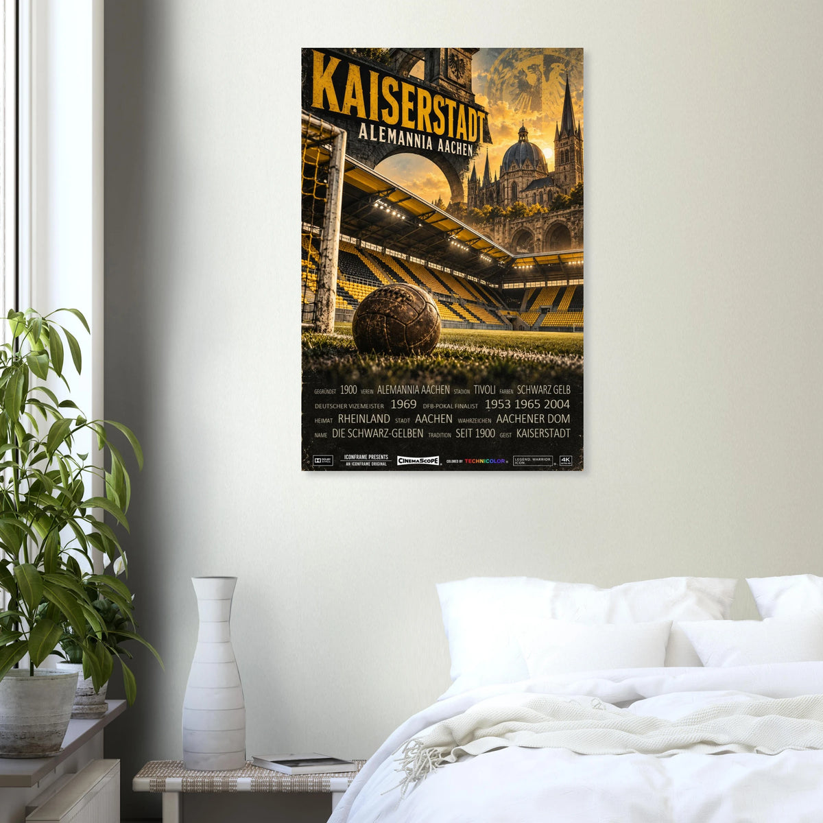 Alemannia Aachen Poster „Kaiserstadt“ an einer hellen Wand über einem weiß bezogenen Bett