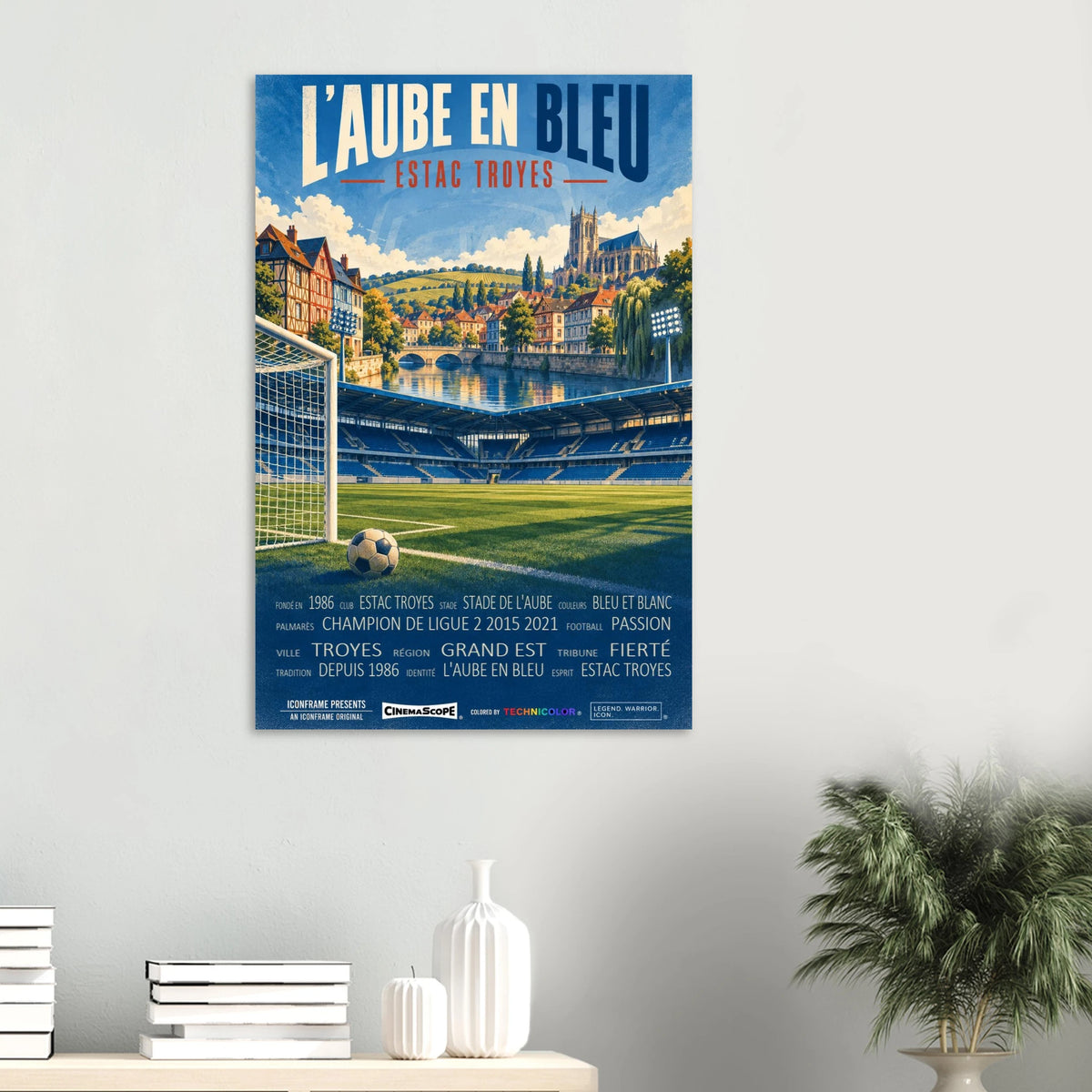 ES Troyes AC Poster „L’Aube en Bleu“ an einer hellen Wand über einer Ablage mit Büchern und Vasen