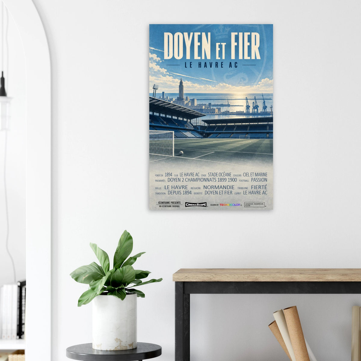Le Havre AC Poster „Doyen et Fier“ an einer hellen Wand neben einer Pflanze und einem Tisch