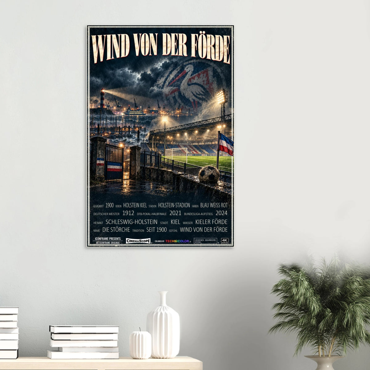 Holstein Kiel Poster „Wind von der Förde“ an einer hellen Wand über Büchern und weißen Vasen