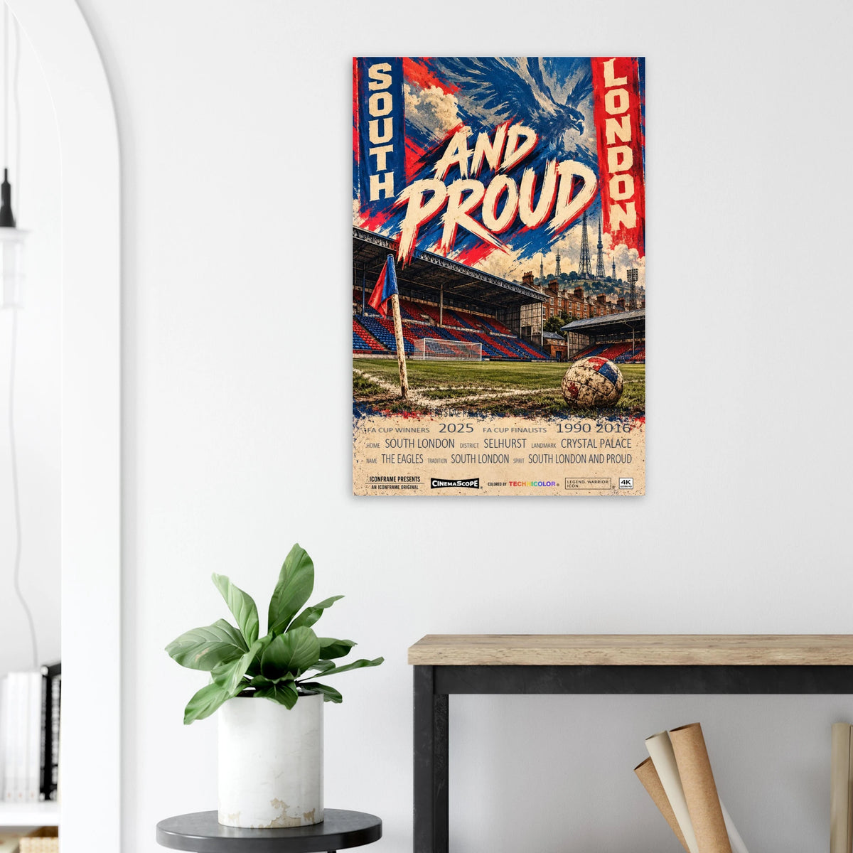Crystal Palace Poster „South London and Proud“ an einer hellen Wand neben einer Pflanze und einem Tisch