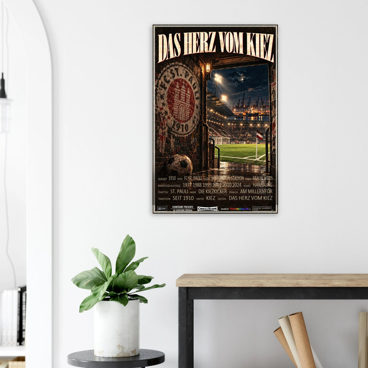 St. Pauli Poster „Das Herz vom Kiez“ an einer hellen Wand neben einer Pflanze und einem Tisch