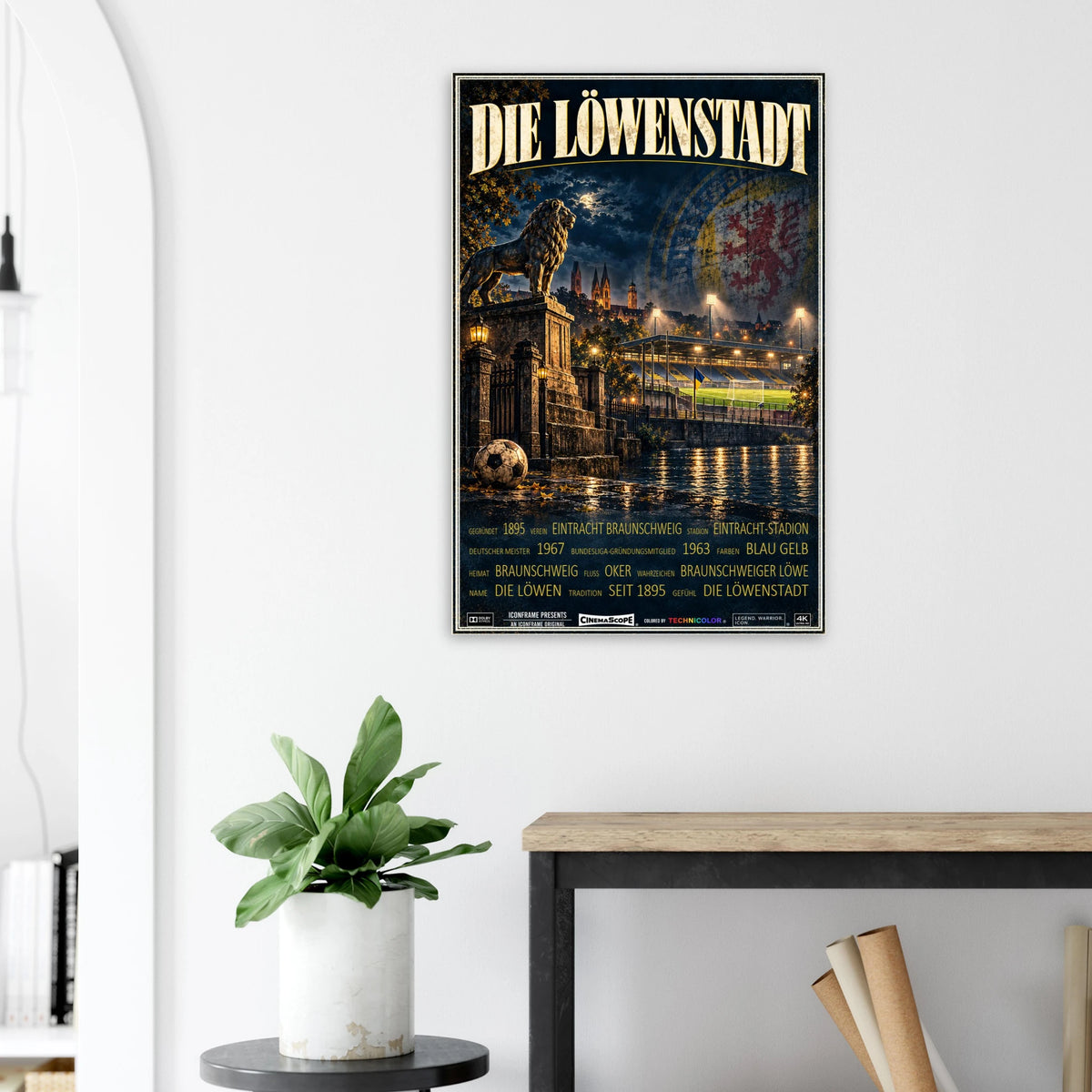 Eintracht Braunschweig Poster „Die Löwenstadt“ an einer hellen Wand neben einer Pflanze und einem Tisch