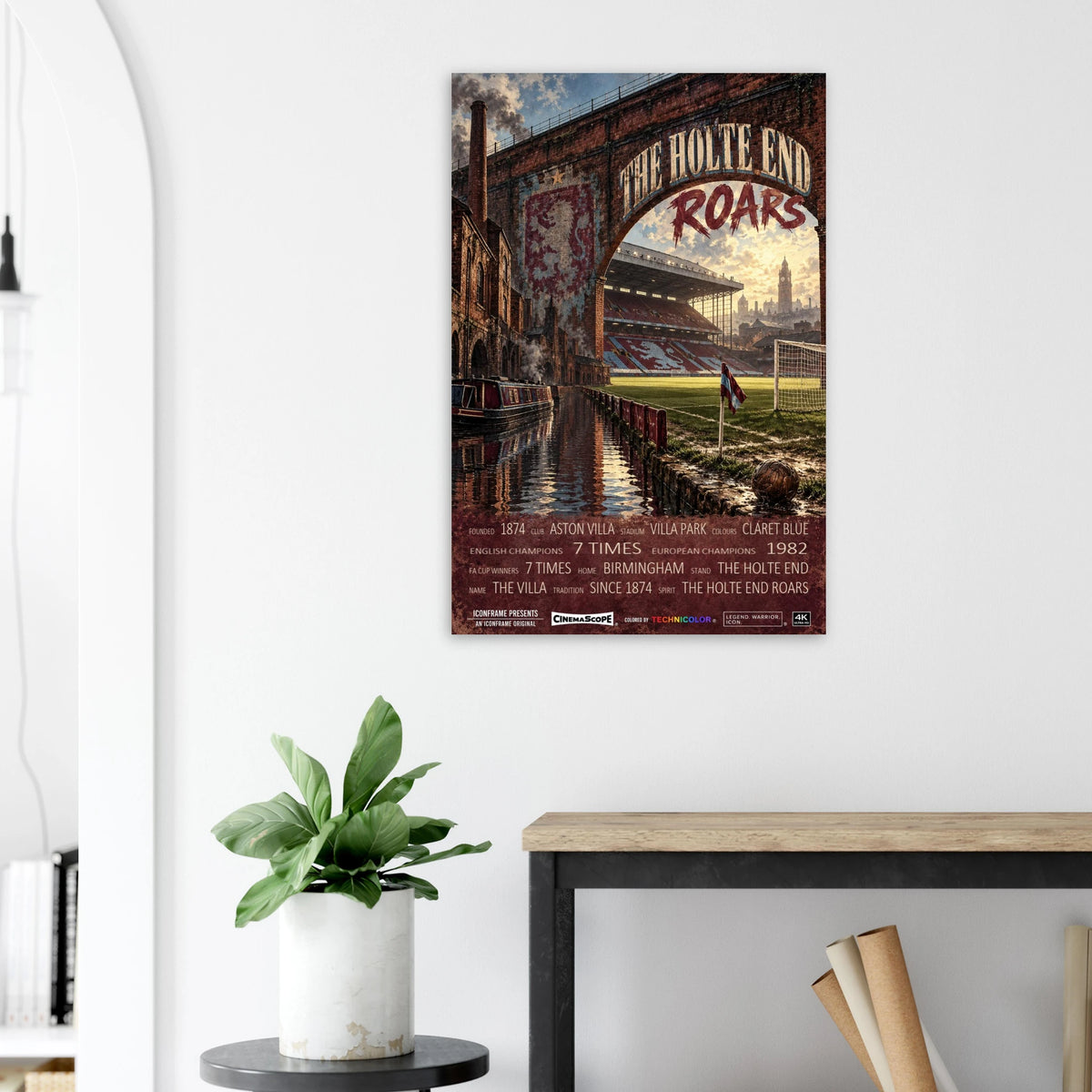 Aston Villa Poster „The Holte End Roars“ an einer hellen Wand neben einer Pflanze und einem Tisch