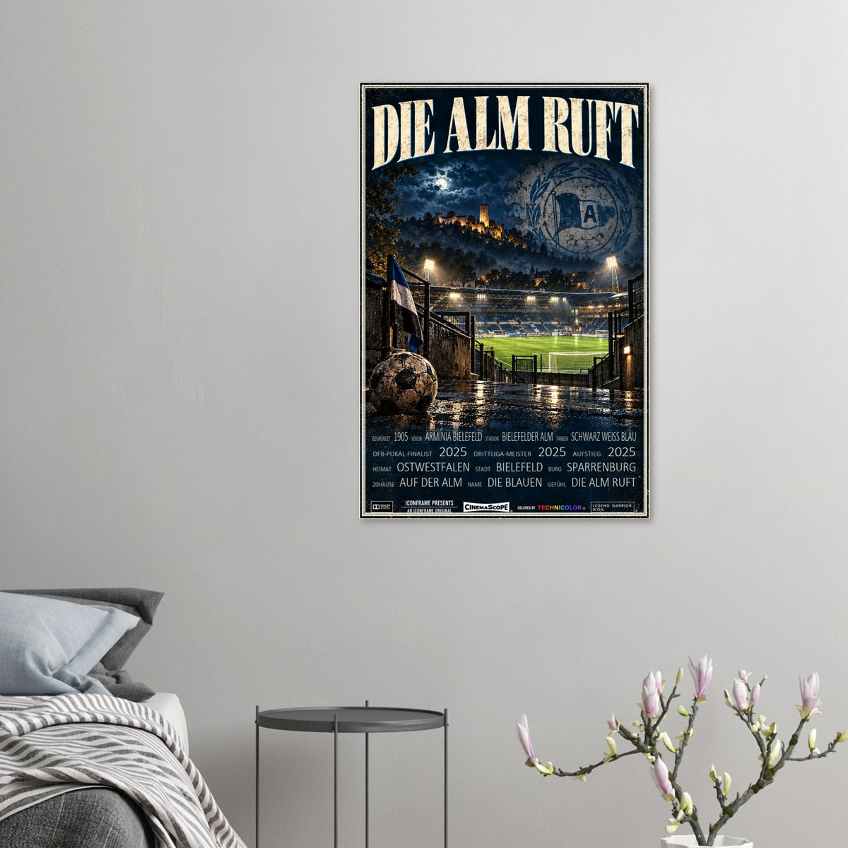 Arminia Bielefeld Poster „Die Alm ruft“ an einer grauen Wand neben einem Bett