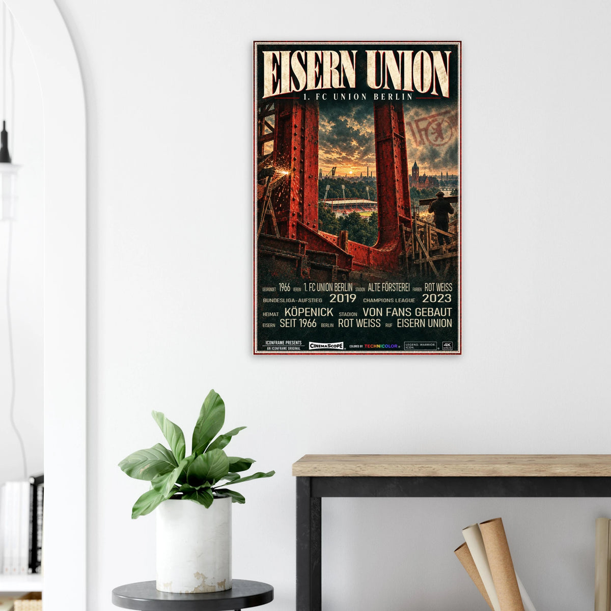 Union Berlin Poster „Eisern Union“ an einer hellen Wand neben einer Pflanze und einem Tisch