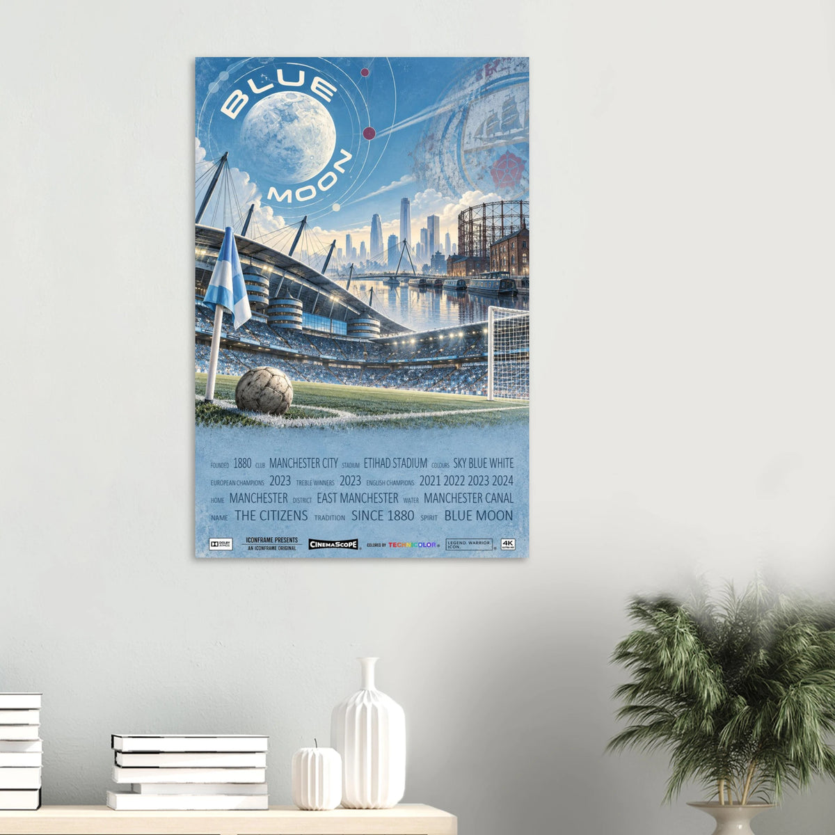Manchester City Poster „Blue Moon“ an einer hellen Wand über Büchern und weißen Vasen