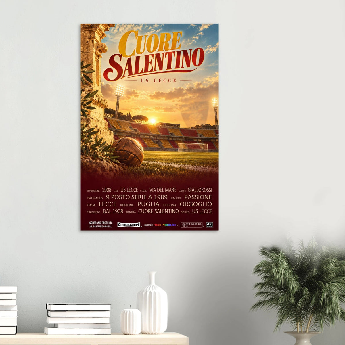 US Lecce Poster „Cuore Salentino“ an einer hellen Wand über einer Ablage mit Büchern und Vasen