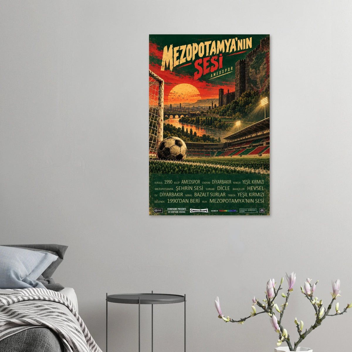 Amed SFK Poster „Mezopotamya’nın Sesi“ an einer grauen Wand neben einem Bett