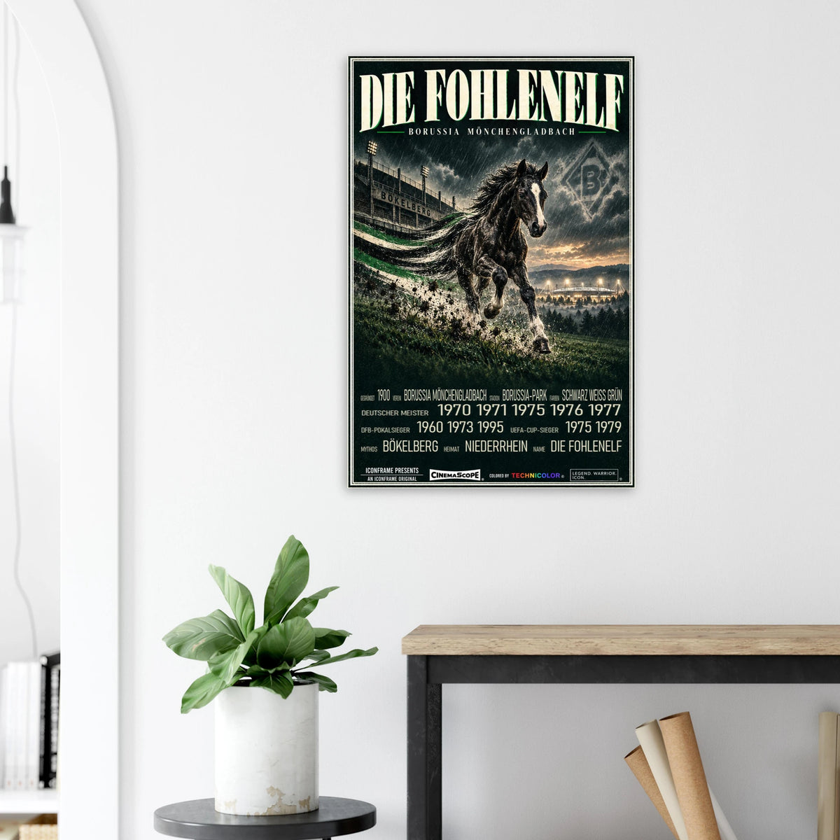 Borussia Mönchengladbach Poster „Die Fohlenelf“ an einer hellen Wand neben einer Pflanze und einem Tisch