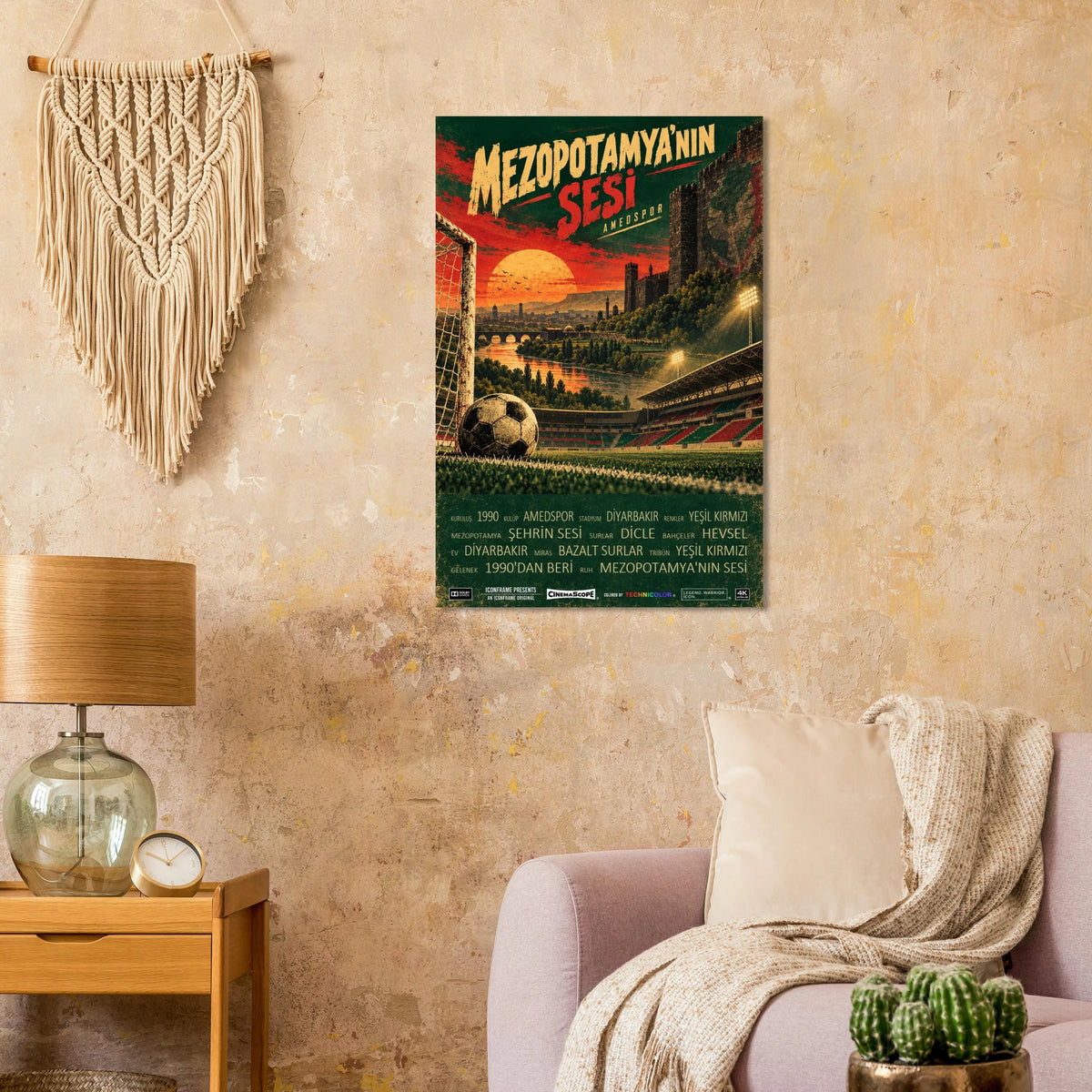 Amed SFK Poster „Mezopotamya’nın Sesi“ an einer beigen Wand neben einem Sessel und einer Tischlampe