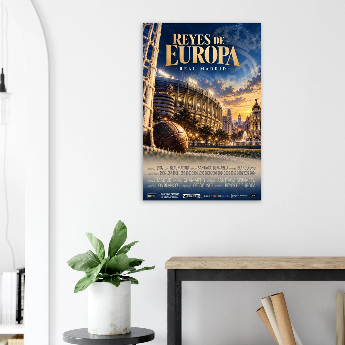 Real Madrid Poster „Reyes de Europa“ an einer hellen Wand neben einer Pflanze und einem Tisch