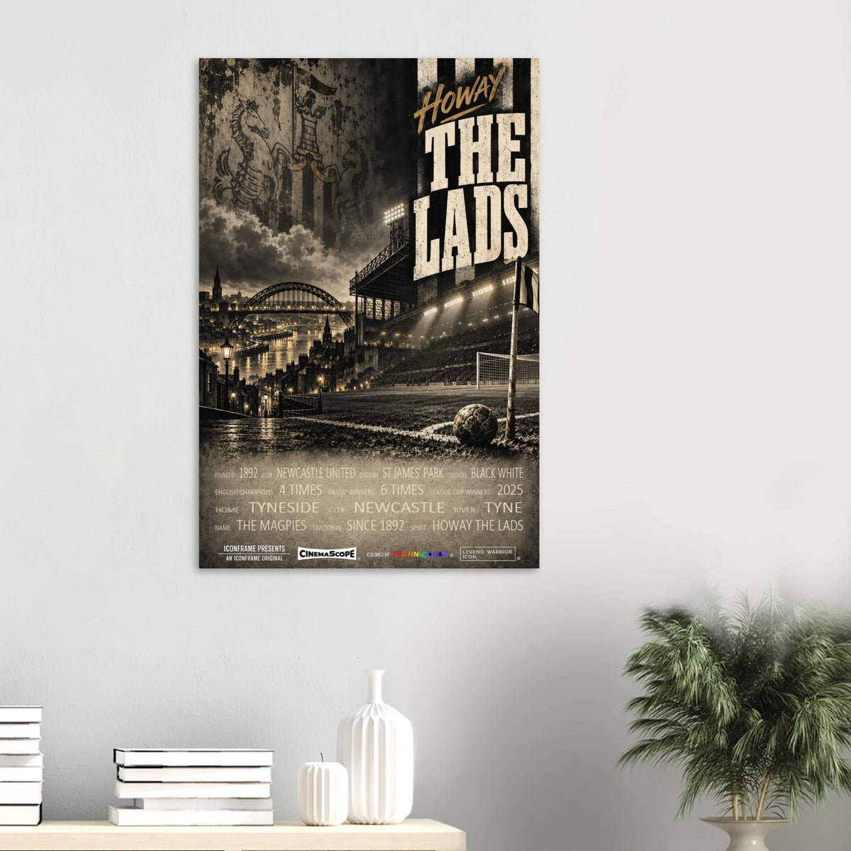 Newcastle United Poster „Howay the Lads“ an einer hellen Wand über Büchern und weißen Vasen