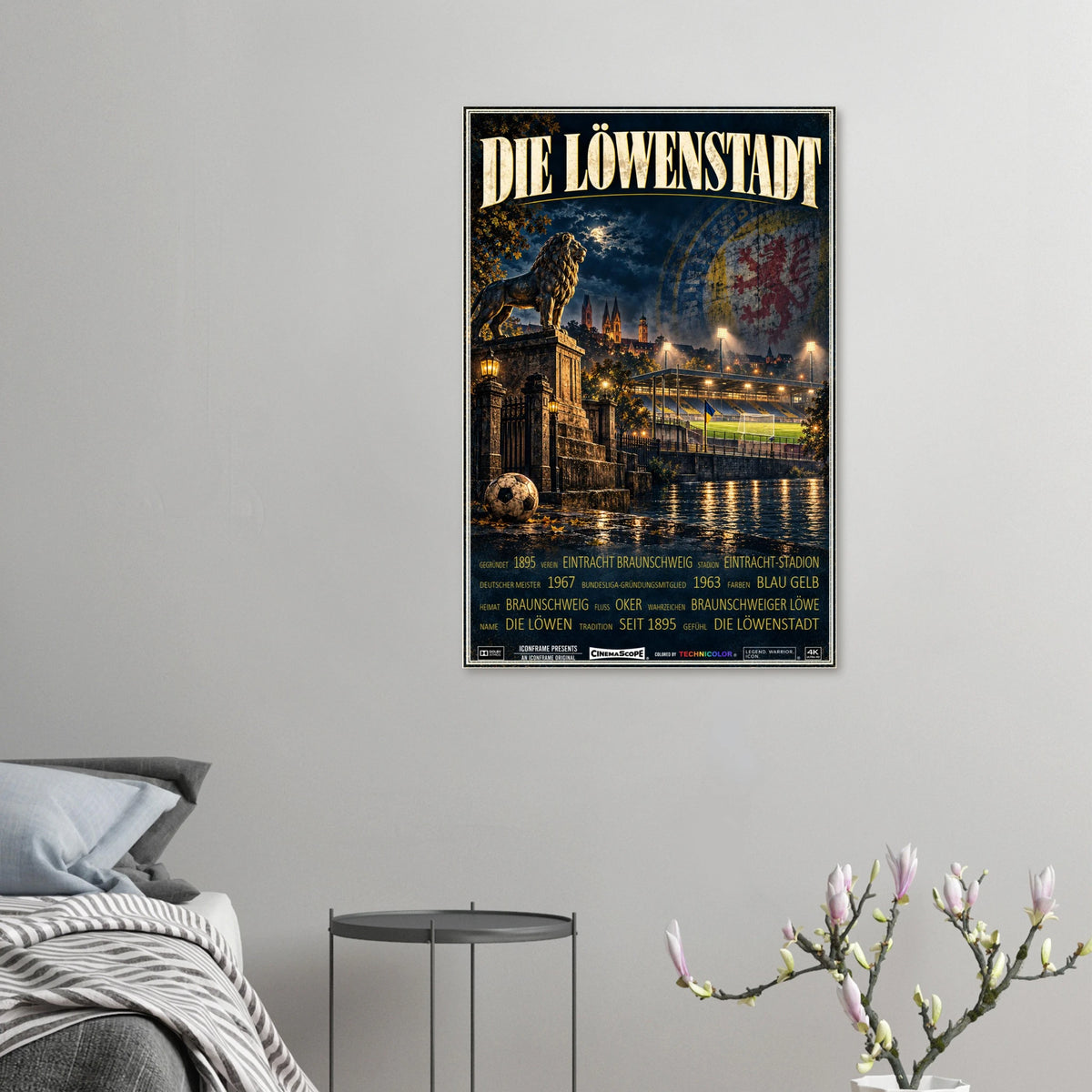 Eintracht Braunschweig Poster „Die Löwenstadt“ an einer grauen Wand neben einem Bett
