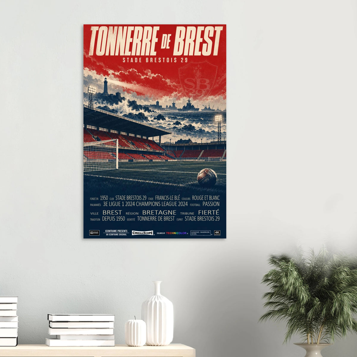 Stade Brest Poster „Tonnerre de Brest“ an einer hellen Wand über einer Ablage mit Büchern und Vasen
