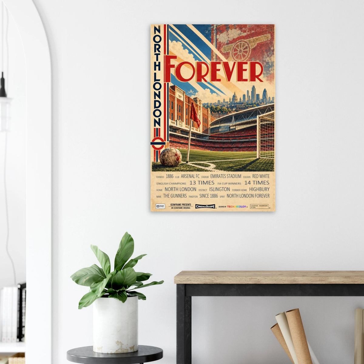 Arsenal Poster „North London Forever“ an einer hellen Wand neben einer Pflanze und einem Tisch