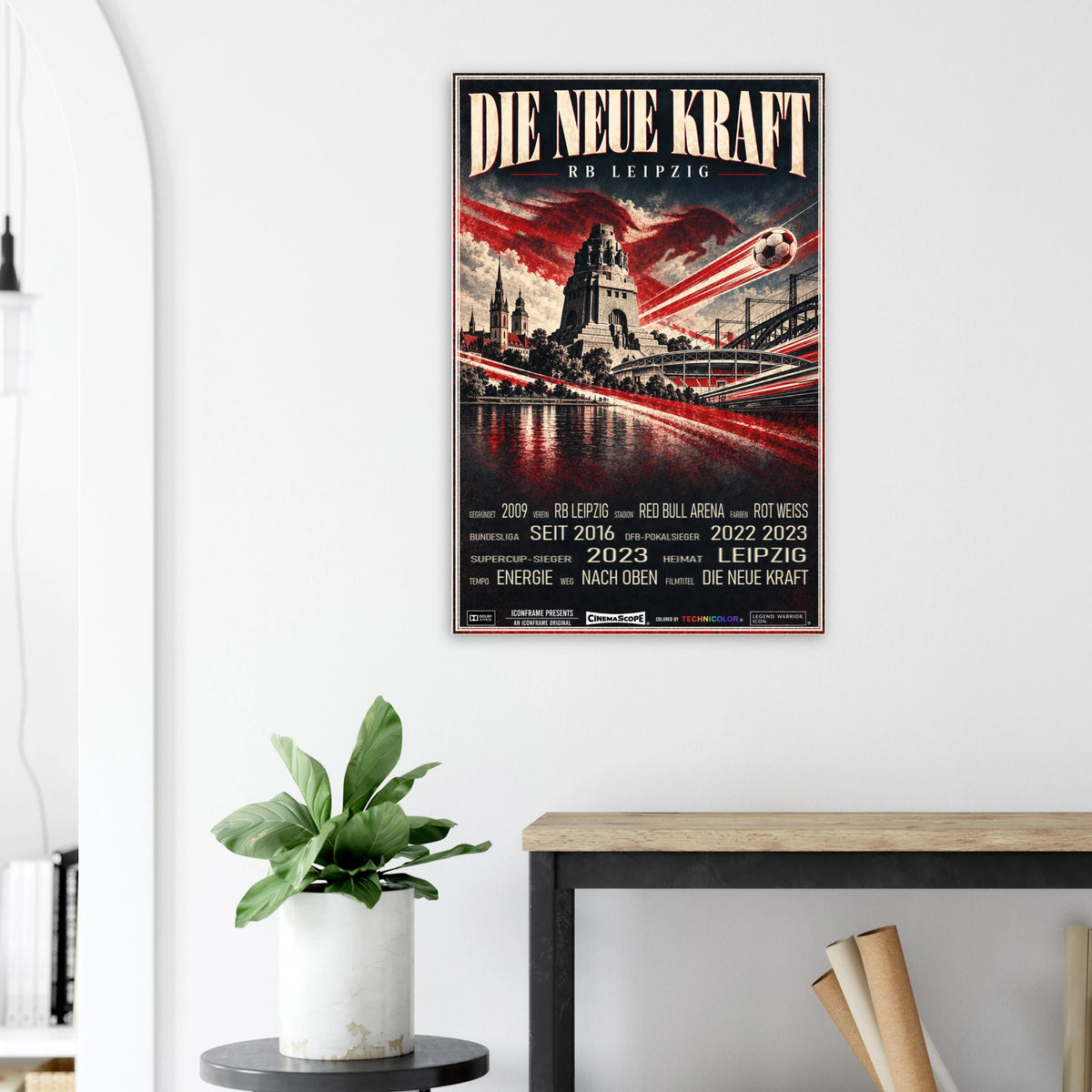 RB Leipzig Poster „Die neue Kraft“ an einer hellen Wand neben einer Pflanze und einem Tisch