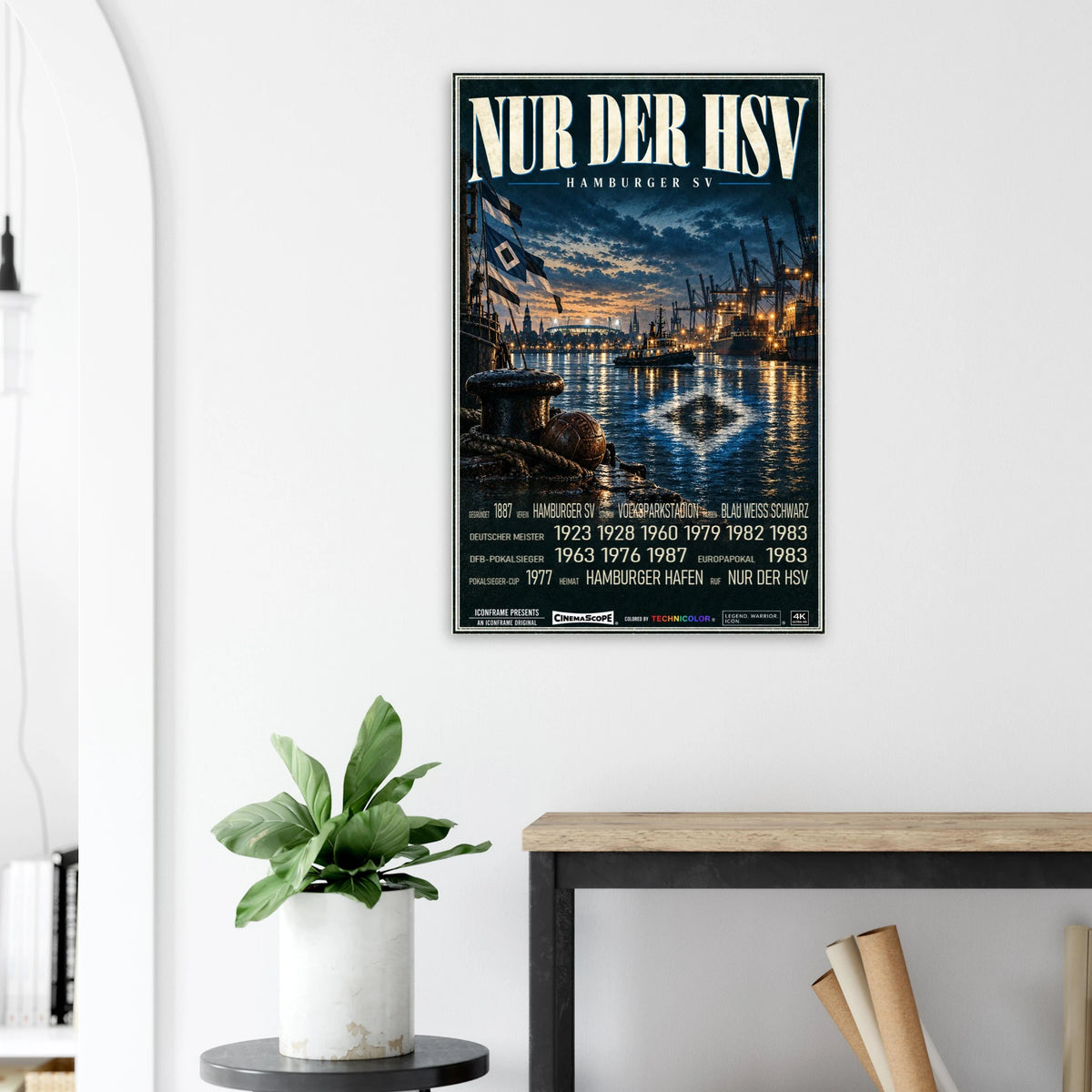 Hamburger SV Poster „Nur der HSV“ an einer hellen Wand neben einer Pflanze und einem Tisch